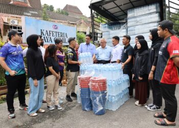 ABDUL RAHMAN Mohamed (tengah) menyerahkan air mineral kepada para pelajar USM di Gelugor, Pulau Pinang sebagai persediaan menghadapi gangguan bekalan air yang bermula esok.