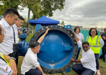 CHOW Kon Yeow (duduk,kiri) dan Pathmanathan meneliti injap yang akan ditukar di LRA Sungai Dua, Pulau Pinang, petang tadi. - Pix: SITI NUR MAS ERAH AMRAN