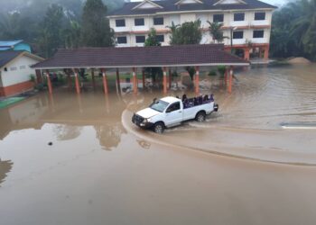 MURID tahap dua SK Pelak diangkut menggunakan Toyota Hilux kerana sekolah mereka dinaiki air banjir di Kampung Pelak di Pekan, Pahang.