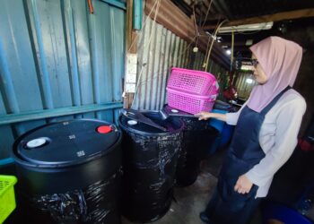 SURINA Ahmad menunjukkan air yang disimpan di dalam tong yang digunakan di kedai makannya di Teluk Kumbar, Pulau Pinang sepanjang ketiadaan bekalan air bermula hari ini. - Pic: IQBAL HAMDAN