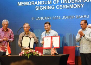 MOHD. RAFIZI Ramli (dua dari kanan) bersama rakan sejawatnya Gan Kim Yong bertukar dokumen selepas menandatangani MoU Zon Ekonomi Khas Johor-Singapura (JS-SEZ) sambil disaksikan  oleh Anwar Ibrahim dan Lee Hsien Loong di Hotel Double Tree, Johor Bahru. .