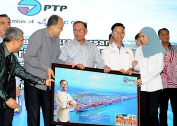 ANWAR Ibrahim menerima cenderamata yang disampaikan oleh pekerja PTP sambil diperhatikan oleh Syed Mokhtar Al-Bukhary sempena Majlis Ramah Mesra Bersama Anggota PTP di Iskandar Puteri.