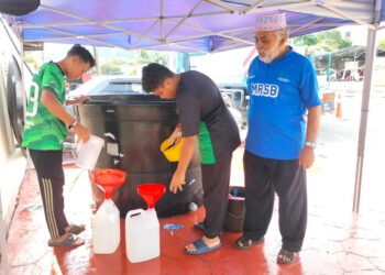 PEGAWAI Masjid Ridwaniah, Ahmad Kechik (kanan) memerhatikan sukarelawan Masjid Ridwaniah di Sungai Batu, Teluk Kumbar, Pulau Pinang mengisi air ke dalam botol untuk memudahkan penduduk setempat mendapatkan bekalan air sepanjang gangguan air berlaku di kawasan itu.