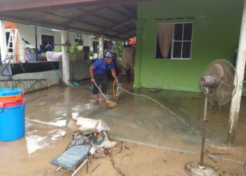 SEORANG penduduk Kampung Maju Jaya, Jalan Kempas Lama, Johor Bahru membersihkan kediaman yang dilanda banjir.