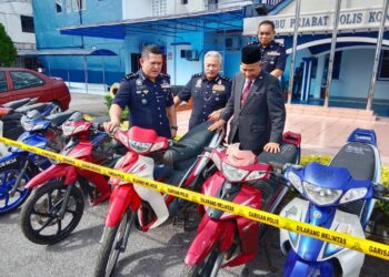 MAZLI Mazlan (kiri) menunjukkan sebahagian daripada motosikal yang dilucut hak di IPK, Kuala Terengganu, hari ini. - UTUSAN/TENGKU DANISH BAHRI TENGKU YUSOFF