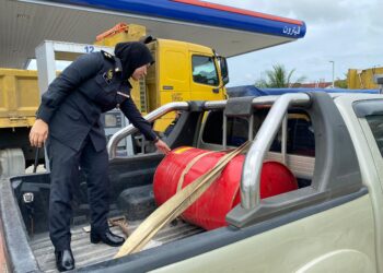 SEORANG pegawai penguatkuasa KPDN Temerloh memeriksa tong mengandungi minyak diesel tanpa kebenaran Pengawal Bekalan Malaysia di Temerloh, Pahang.