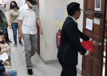 TEOH Joo Leong, 47, (bertopi hitam) ketika dihadapkan di Mahkamah Majistret Butterworth, Pulau Pinang hari ini, atas pertuduhan memandu dalam keadaan mabuk sehingga mengakibatkan kematian dua guru lelaki pada 16 Disember tahun lalu.- Pix: SITI NUR MAS ERAH AMRAN