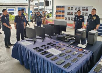 KHAW Kok Chin (kanan) menunjukkan antara peralatan yang dirampas daripada sindiket judi online dalam sidang akhbar di IPK Pulau Pinang, George Town, Pulau Pinang. - Pix: IQBAL HAMDAN
