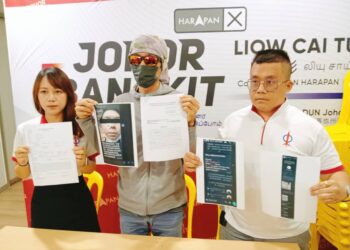 CHONG (tengah) menunjukkan tangkap layar mesej yang diterimanya daripada kumpulan ah long di Pusat Khidmat DUN Johor Jaya, Johor Bahru.