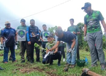 MOHD. Rashdan Muda (tiga, kanan) menanam pokok kapur pada Program Kerjasama Penanaman Pokok 'One Tree One Staf' bersama Golden Pharos Berhad di kawasan Hutan Rimba Bandar Bukit Bauk, Dungun, hari ini. - UTUSAN/NIK NUR IZZATUL HAZWANI NIK ADNAN