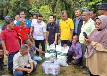 ARTHUR Joseph Kurup (tengah) menyampaikan bantuan baja dan kit agro makanan kepada petani pada program Sentuhan Agro Madani peringkat Parlimen Paya Besar di Kampung Sungai Atong di Kuantan, Pahang. - FOTO/ASZAHARI ALI