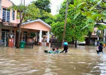 KANAK-kanak mengambil kesempatan bermain air banjir di Taman Alamanda 3, Kuala Terengganu. semalam.  -  UTUSAN/KAMALIZA KAMARUDDIN