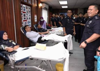 MAZLI Mazlan (kanan) beramah mesra dengan anggota polis yang menyertai program menderma darah di IPK Terengganu di Kuala Terengganu, hari ini. - UTUSAN/TENGKU DANISH BAHRI TENGKU YUSOFF