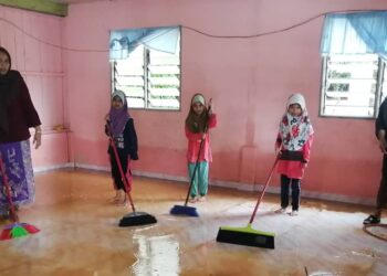 SULONG Hasan (kanan) bersama ahli keluarga membersihkan rumah mereka setelah banjir surut di Kampung Kepah, Hulu Terengganu, hari ini. - UTUSAN/NOOR HAYATI MAMAT