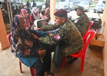 PASUKAN Forward Medical Team daripada Angkatan Tentera Malaysia melakukan pemeriksaan kesihatan terhadap mangsa-mangsa banjir di PPS Kampung Shukor, Hulu Dungun, hari ini. - UTUSAN/PUQTRA HAIRRY ROSLI