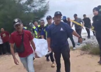 ANGGOTA  polis mengusung mayat salah seorang suspek yang ditemukan lemas di
Pantai Teluk Lipat, Dungun, semalam.