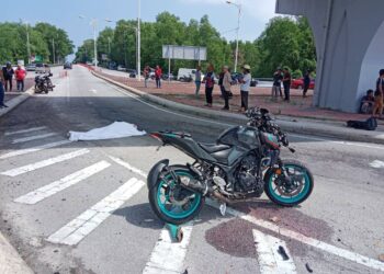 KEADAAN motosikal dan mayat Ishak Abd. Rahman setelah motosikal ditunggangnya bergesel dengan sebuah treler di Kuala Nerus, hari ini.