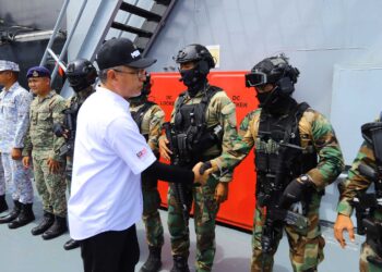 ADLY Zahari bersalam dengan anggota keselamatan yang bertugas melaksanakan OP PASIR di Pangkalan Laut Tun Sharifah Rodziah.
