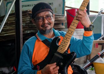 ZULKIFLI Abdul Hamid memetik gitarnya ketika ditemui di Pejabat SWM Environment, Cheng, Melaka. - UTUSAN/SYAFEEQ AHMAD