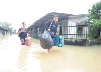 PENDUDUK meninggalkan rumah masing-masing kerana dinaiki air di Kampung Laut Skudai, Johor Bahru. - UTUSAN/RAJA JAAFAR ALI