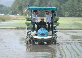 MOHAMAD Sabu (tengah) mengendalikan jentera mesin menanam padi semasa Majlis Perasmian SMART SBB Ala Sekinchan di Kawasan Lembaga Kemajuan Pertanian Kemubu (KADA) di Bendang Tok Ajam, Pasir Putih, Kelantan. – UTUSAN/KAMARUL BISMI KAMARUZAMAN