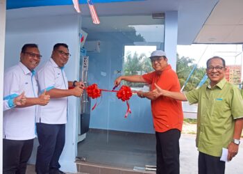 ZAMRI Mohamad (dua, kanan) melancarkan mesin ATM menggunakan tenaga solar yang pertama di negara ini dalam kawasan ladang sawit Bandar Tun Razak, Keratong di Rompin, Pahang.