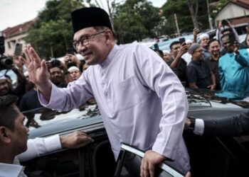 ANWAR Ibrahim melambaikan tangan kepada jemaah masjid selepas menunaikan solat Jumaat di Masjid Al-Hijrah, Persiaran Desa Pinggiran Putra, Putrajaya, semalami. - UTUSAN/FAIZ ALIF ZUBIR