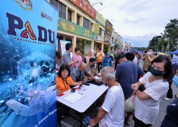 PENGUNJUNG Pasar Malam Taman Bukit Galena, Seremban mengambil peluang untuk mengemas kini maklumat mereka menerusi inisiatif 'booth' bergerak yang dilaksanakan oleh Pejabat DUN Bukit Kepayang dengan kerjasama Jabatan Perangkaan Malaysia, Negeri Sembilan petang semalam.-UTUSAN/MOHD. SHAHJEHAN MAAMIN.