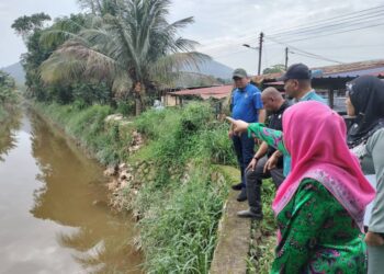 SHARIFAH AZIZAH Syed Zain menunjukkan tali air di Taman Ilham, Kluang yang perlu diperdalamkan bagi menangani masalah banjir di kawasan tersebut.