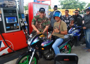RAIS YASIN mengisi petrol pada sebuah motosikal ketika Program Isi Minyak Percuma di sebuah stesen minyak di Krubong, Melaka. - UTUSAN/AMRAN MULUP