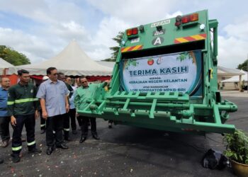 HILMI Abdullah (kanan) menyempurnakan gimik penyerahan lori kompaktor baharu kepada MPKB pada Program 'Jupo Mato' Kelantanku Bersih di MPKB Jabatan Perkhidmatan Bandar di Panji, Kota Bharu, Kelantan hari ini. UTUSAN/MUSTAQIM MOHAMED.