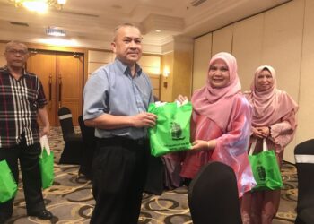 IZANI Ismail (kanan) menyampaikan cenderamata kepada wakil media pada Majlis Apresiasi Media- AKSB di Kota Bharu, Kelantan.UTUSAN/ROSMIZAN RESDI