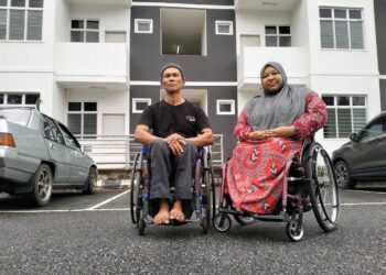 SYARIFAH Raudzah Syed Akil (kanan) bersama suami gembira selepas selamat menduduki rumah baharu di PPR Batang Merbau di Tanah Merah, Kelantan.-UTUSAN/ROHANA ISMAIL.