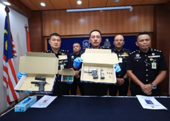 MUHAMAD Zaki Harun (tengah) bersama pegawai menunjukkan pistol yang dirampas selepas menahan dua lelaki dalam serbuan di Kampung Pasir Kelang, Kuala Krai, Kelantan semalam-UTUSAN/KAMARUL BISMI KAMARUZAMAN.