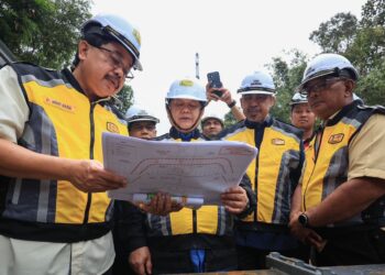 ALEXANDER Nanta Linggi (tengah) diberi penerangan oleh Pengarah Cawangan Senggara Fasiliti Jalan JKR Ir Mohd. Nasir Bontat semasa membuat lawatan di lokasi runtuhan Jalan Dabong-Jeli di Kampung Kubur Datu, Jeli, Kelantan hari ini-UTUSAN/KAMARUL BISMI KAMARUZAMAN