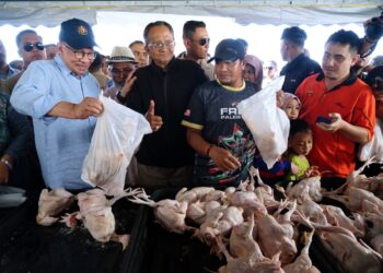 ANWAR Ibrahim (kiri) melawat gerai jualan pada Program Jualan Termurah Madani Barang Basah dan Kering di Padang Taman Klebang Restu, Ipoh hari ini. - UTUSAN/ZULFACHRI ZULKIFLI