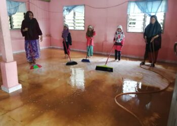 SULONG Hasan (kanan) bersama ahli keluarga membersihkan rumah setelah banjir surut di Kampung Kepah, Hulu Terengganu, semalam. – UTUSAN/NOOR HAYATI MAMAT