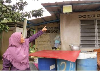 RAPIAH Ismail menunjukkan lampu solar yang digunakan bagi menerangi rumah penduduk Kampung Sungai 
Bayu Dalam, Gua Musang, Kelantan. – UTUSAN/AIMUNI TUAN LAH