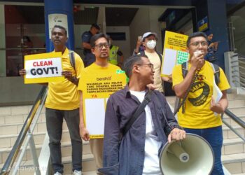 SEBAHAGIAN peserta himpunan anjuran Bersih dan beberapa NGO memegang plakad berkaitan DNAA melibatkan ahli politik.