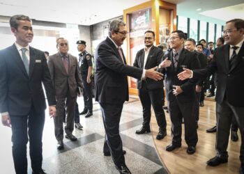 WAN Ahmad Dahlan Abdul Aziz mengimbas kad perakam waktu sebagai simbolik memulakan tugas di JPA Putrajaya. - UTUSAN/FAIZ ALIF ZUBIR