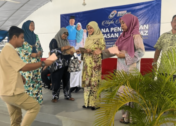 SALAH seorang pelajar menerima sumbangan disampaikan oleh Datin Seri Shamsiah Yasin (tiga dari kanan) sewaktu Majlis Sumbangan Dana Pendidikan Yayasan Fawwaz di Pusat Khidmat Kubang Gajah, Arau, Perlis. -UTUSAN/ASYRAF MUHAMMAD