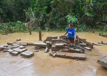 TENGKU Alwi Tengku Ahmad melihat tangga dan tiang batu di tapak rumahnya yang hanyut dalam kejadian kepala air di Kampung Shukor, Hulu Dungun, semalam. – UTUSAN/PUQTRA HAIRRY ROSLI