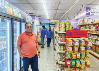 MOHD.IZHAR di hadapan salah sebuah rangkaian kedai milik KOPRO.