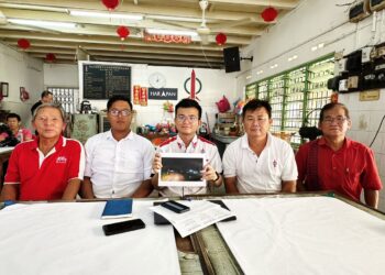 STEVEN Tiw Tiee Siang (tengah) menunjukkan gambar keadaan jalan yang gelap di salah sebuah kampung baru berikutan elektrik lampu jalan dipotong disebabkan tunggakan bil dalam sidang akhbar di Batu Gajah hari ini. - UTUSAN/LIYANA RAMLI