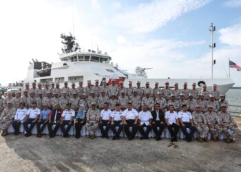 RUJI Ubi (duduk/ tengah) bersama barisan di hadapan kapal OPV1 itu di Limbungan TH Heavy Engineering (THHE) Pulau Indah, Klang, Selangor. -UTUSAN/ AFIQ RAZALI