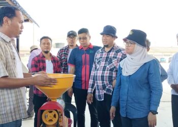 AZULITA Salim (kanan) melihat pesawah memproses beras menggunakan mesin mini ketika melawat  pusat pembelian padi PPK Tanjung Piandang di Parit Buntar hari ini. - UTUSAN/WAT KAMAL ABAS