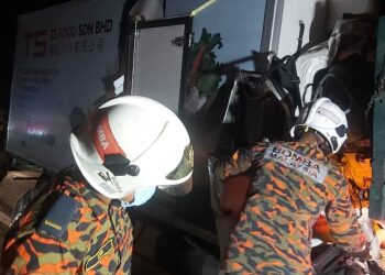 ANGGOTA bomba mengeluarkan mangsa yang tersepit dalam kenderaan dalam nahas di Kilometer 314.5, Lebuh Raya Utara Selatan arah utara dekat Tapah hari ini. - UTUSAN/IHSAN JBPM