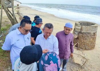 RAZALI Idris (tengah) diberi taklimat pembinaan tembok penghadang ombak untuk 
melindungi perigi di Kampung Mengabang Kapal, Batu Rakit, Kuala Nerus, Terengganu. - UTUSAN/KAMALIZA KAMARUDDIN