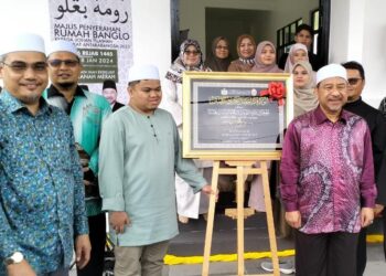 MOHD. Nassuruddin Daud (kanan) semasa menyerahkan banglo kepada Muhammad Qayyim Nizar Sarimi di Wadi Iman Eksklusif Tanah Merah, Kelantan. - UTUSAN/ROHANA ISMAIL