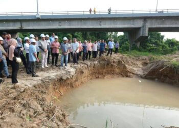 AHMAD Samsuri Mokhtar (barisan depan, tiga kiri) diberi taklimat mengenai kebocoran paip di dasar Sungai Besut, di Besut, semalam.